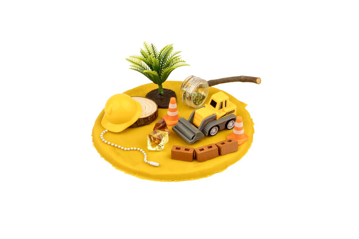 Construction tub opened: yellow doh, a toy truck, cones and bricks